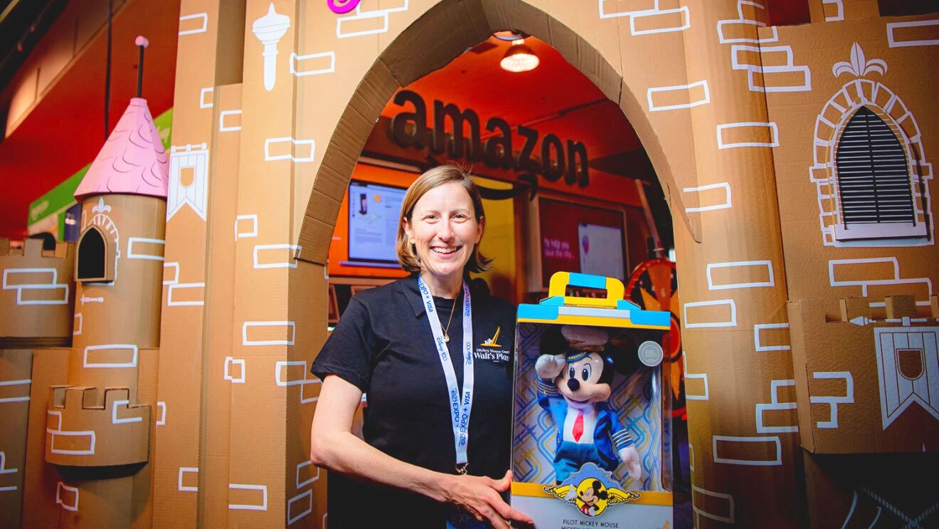 An image of an amazon employee holding a stuffed Mickey Mouse pilot toy.