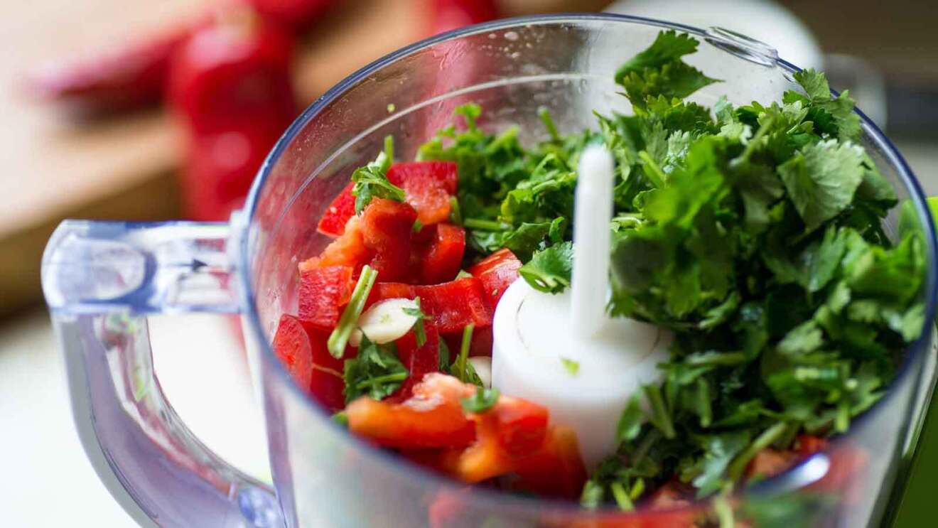 Prime Day 2023 live blog best deals: overhead view of a blender filled with red peppers and cilantro.