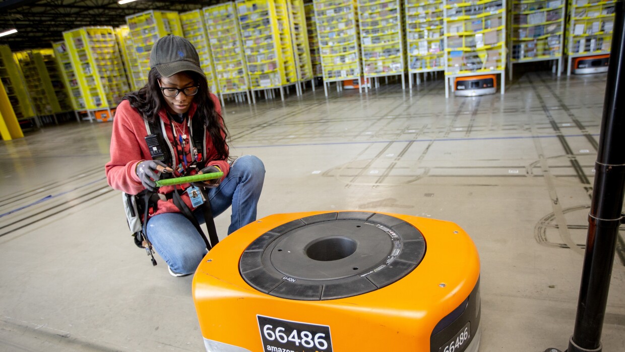 Amazon Robotics technician attends to a fulfillment center robot