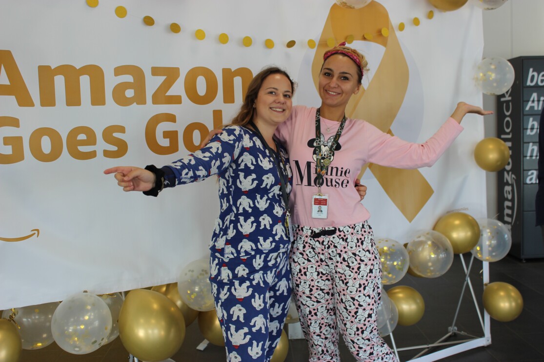 2 Mitarbeiterinnen im Schlafdress vor einer Fotowand mit Goes Gold