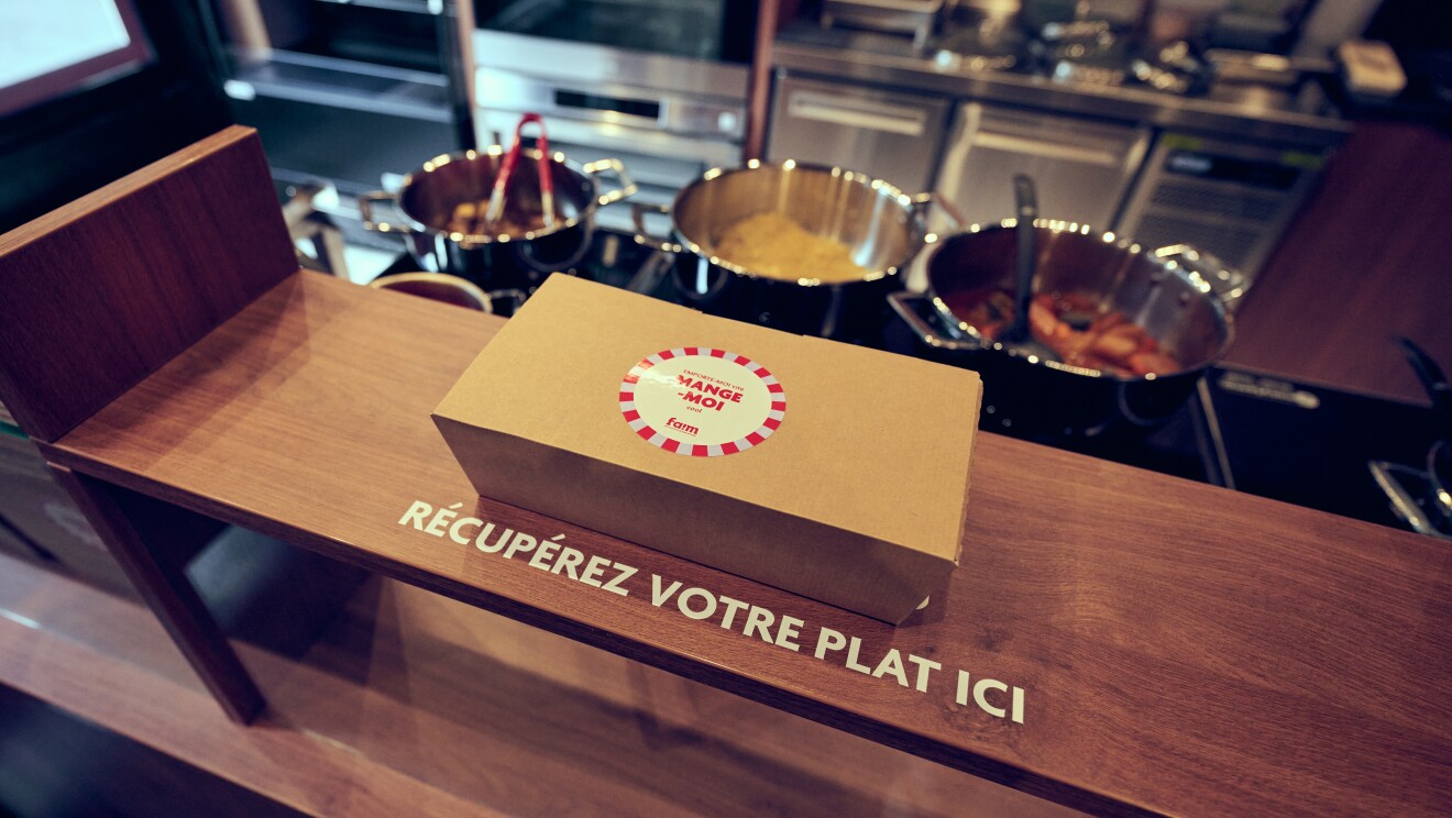Boîte à emporter sur le comptoir avec instructions, casseroles en arrière-plan