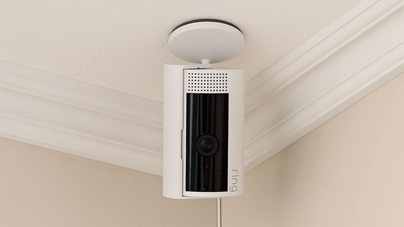 天井からぶら下がっている白い円筒形のセキュリティカメラ。Amazon Ring