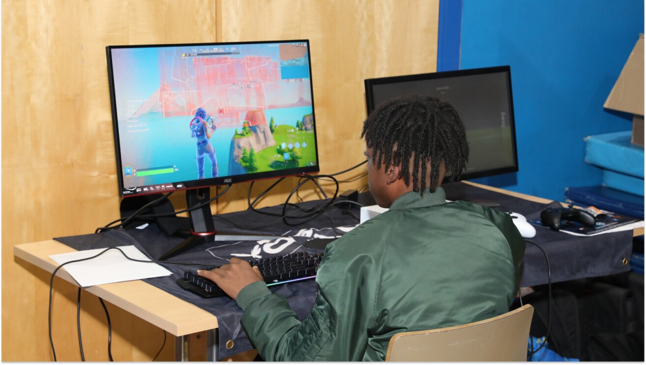 Gamer playing Fortnite on dual-monitor setup