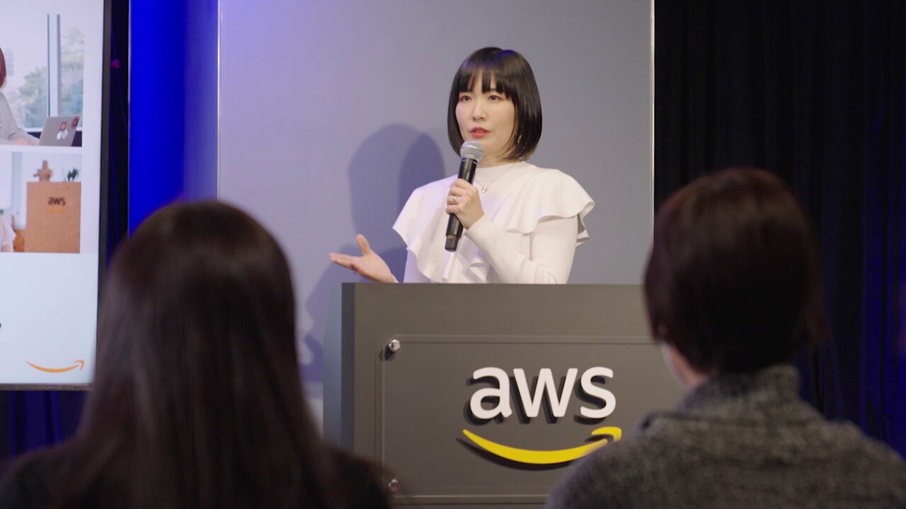 スクリーンの前でプレゼンテーションをする宇都宮聖子さん