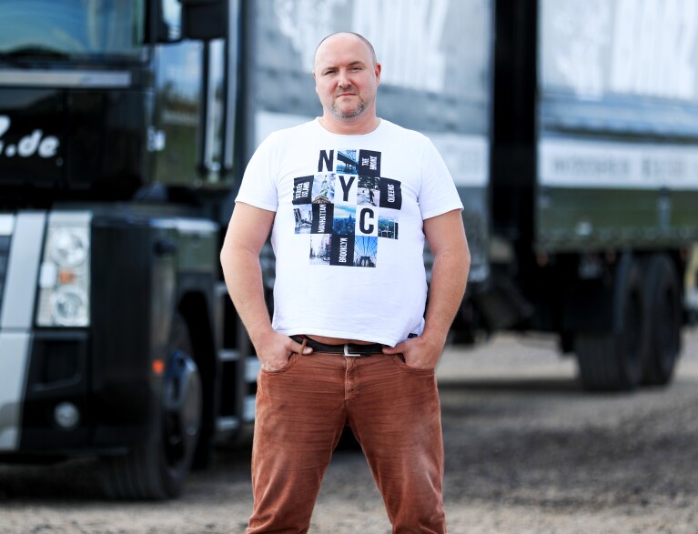 Der Amazon Mitarbeiter Rafal vor dem LKW, mit dem er für seinen LKW Führerschein trainiert.