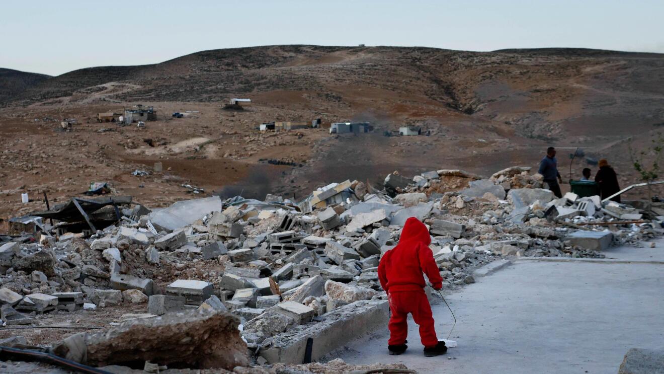 A still from No Other Land showing a young child walking across rubble