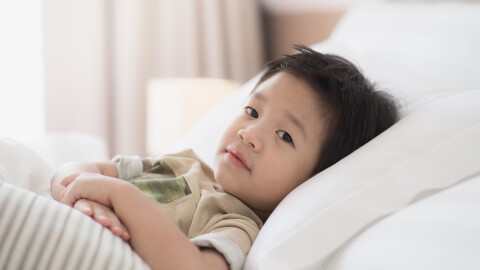 Child lying in white bed