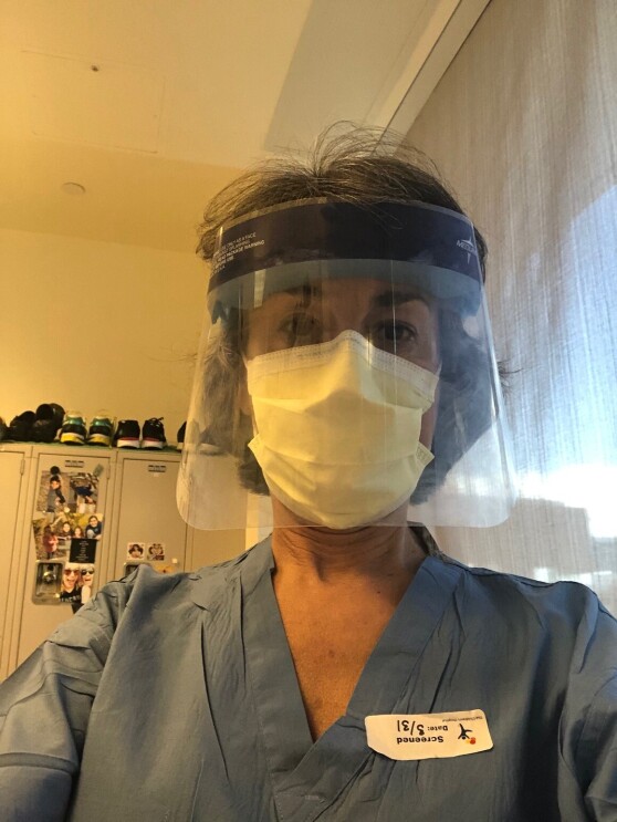 An image of Dr. Gore, a chidhood cancer researcher and physician, wearing a face mask and face shield in her scrubs.