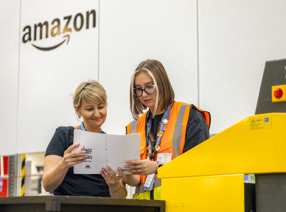 Amazon fulfilment center employees discuss document under company branding