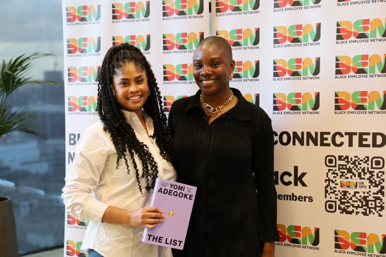 Two young women standing in front of a Black History Month banner 