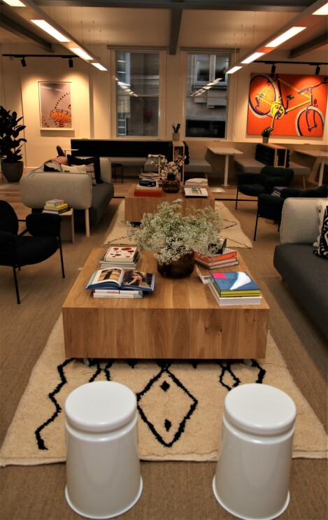 A photo of a social area in the Amazon Manchester offices. You can see a desk covered in books and sofas.