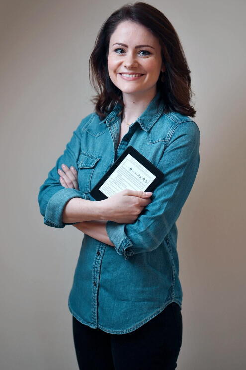 LJ Ross holding an Amazon Kindle device