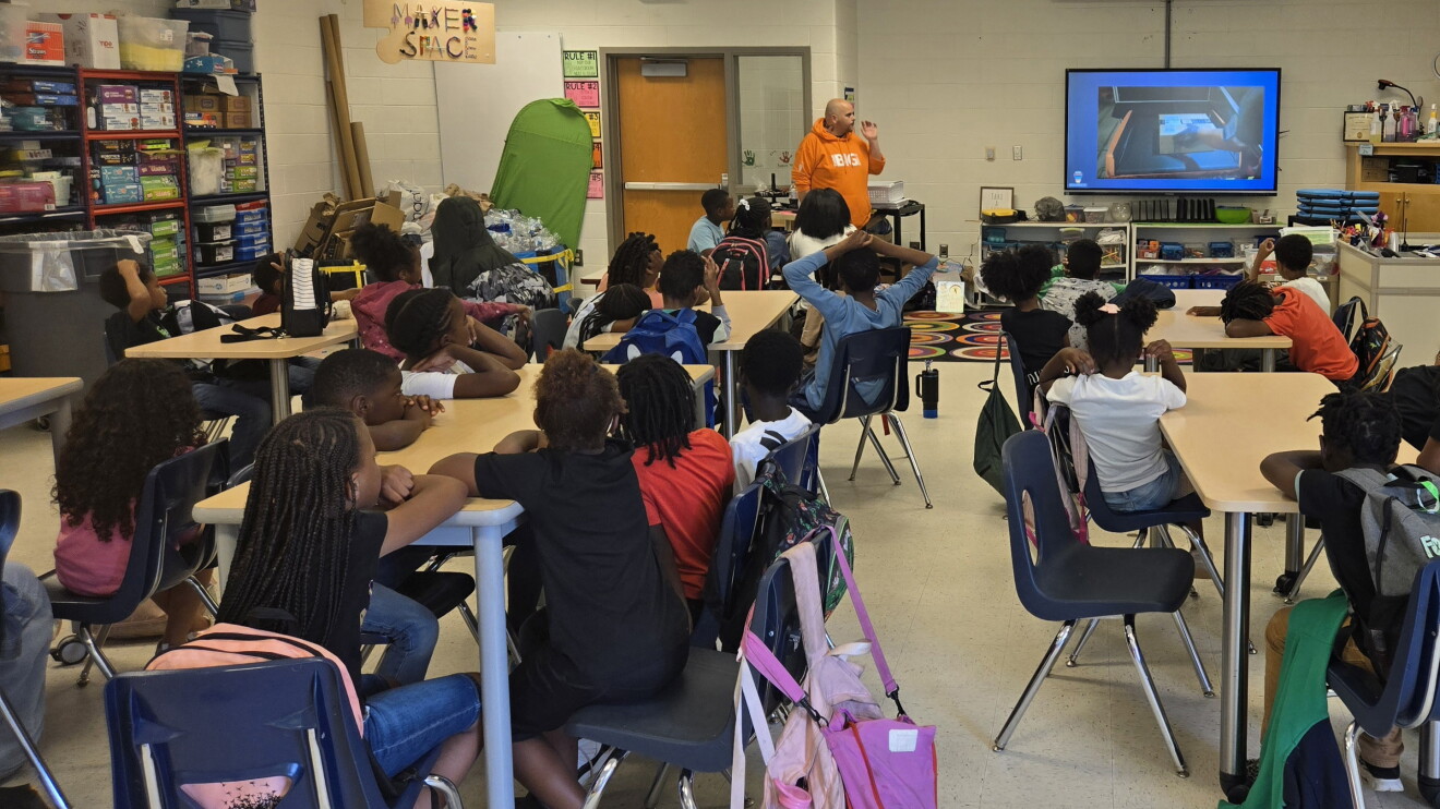 Students attentively watching presentation in maker space classroom