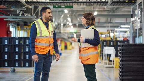 Dso trabajadores de Amazon en un centro logístico robotizado.