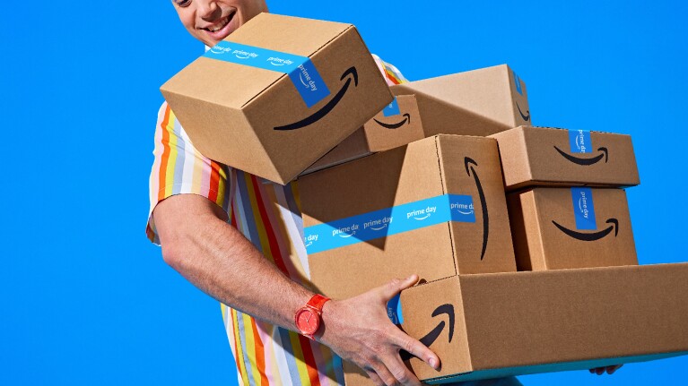 Prime Day 2023 live blog best deals: man holding a bunch of boxes.