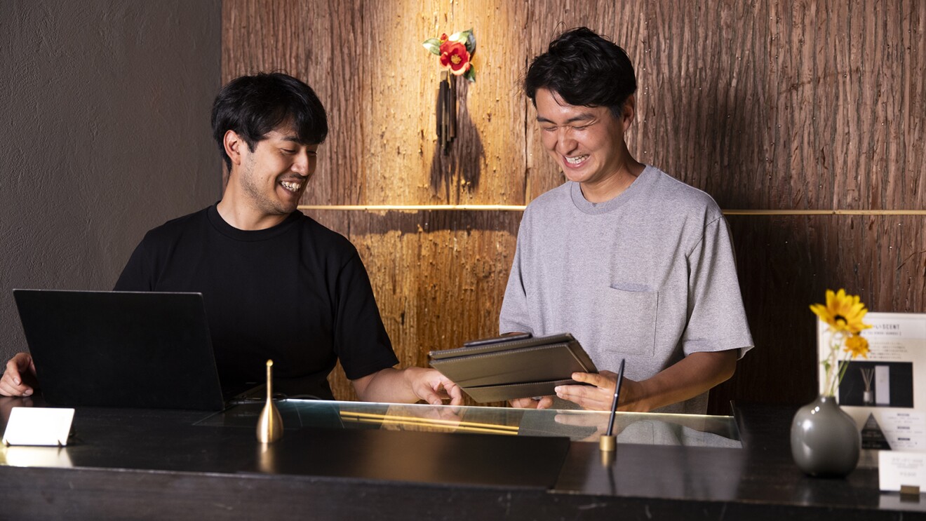 ホテルのカウンターで打ち合わせをしている男性2名