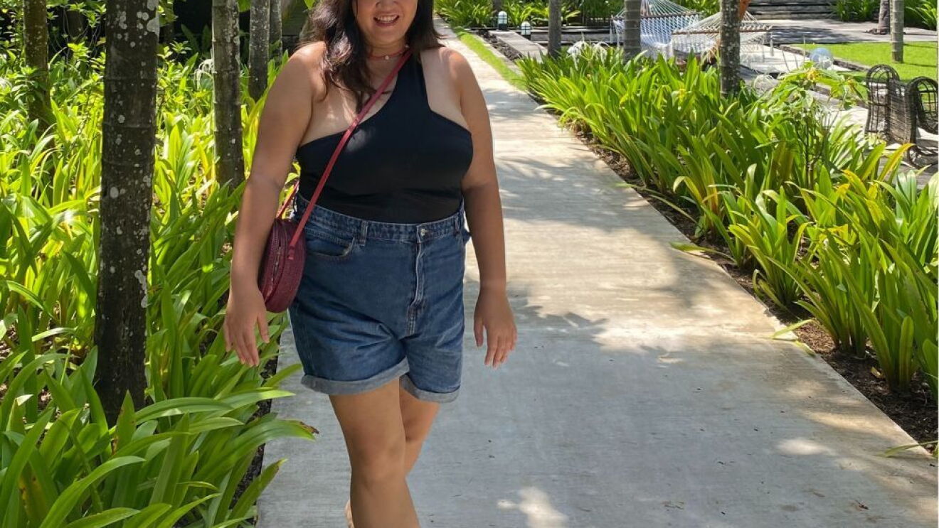 Freelance writer Meryl Koh walking on a path surrounded by trees.