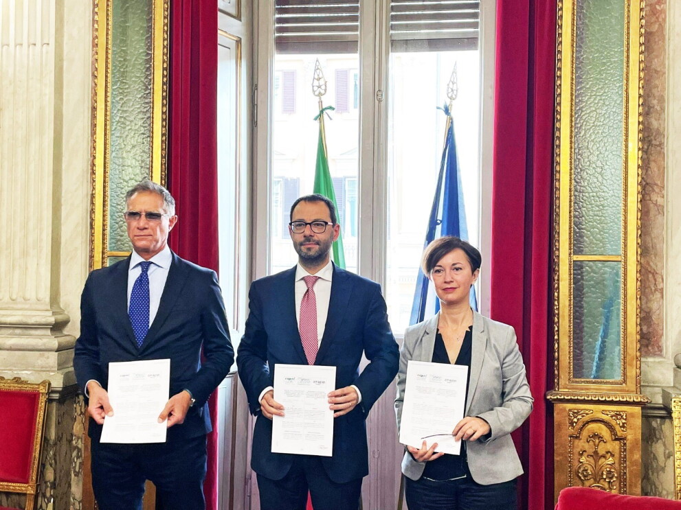 Il Ministro delle Politiche Agricole, Stefano Patuanelli, tiene in mano un protocollo di intesa con accanto Mariangela Marseglia. Alle sue spalle le bandiere dell'Italia e dell'Unione Europea