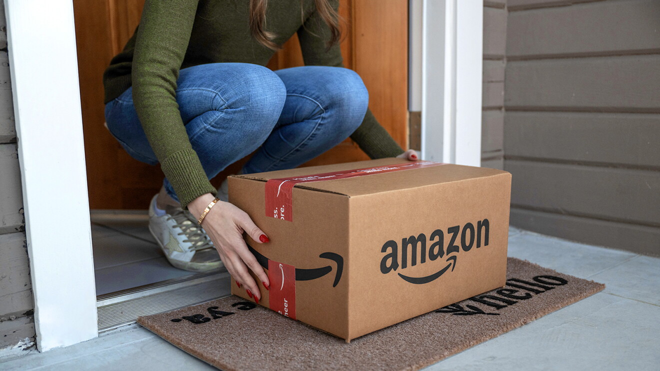 Woman picks up an Amazon package off her front doorstep.