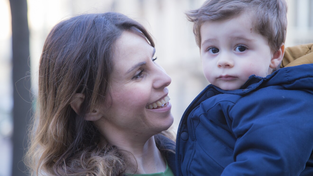 Primo piano di Ilaria di Bartolomeo, Operations Manager del centro di smistamento di Amazon a Casirate, che tiene in braccio suo figlio Matteo.
