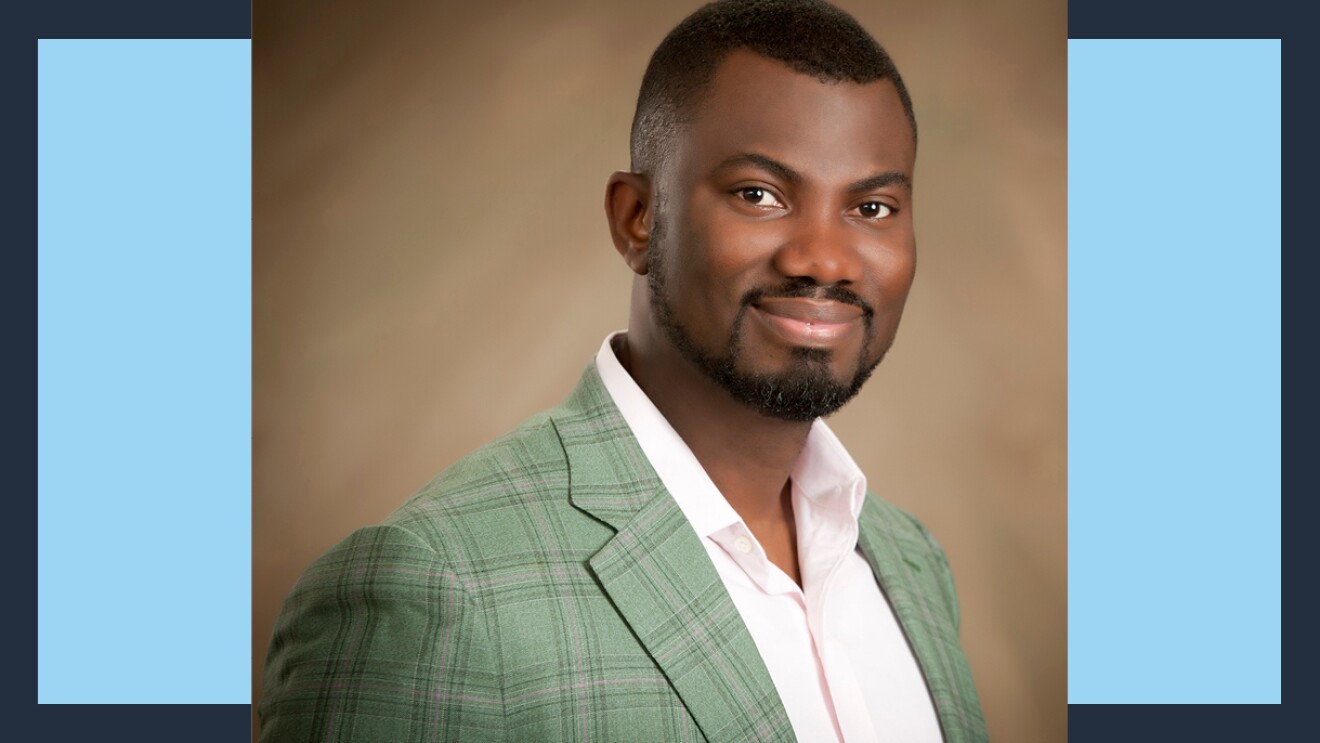 A headshot of Kobe Boateng wearing a green plaid sports jacket.