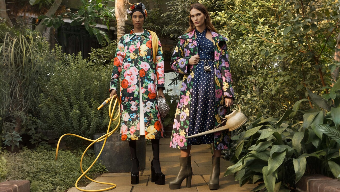 Models wear colourful coats in a green garden