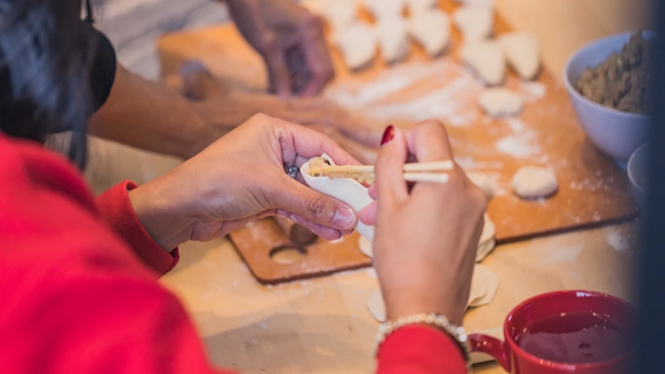Dumpling Daughter founder Nadia Liu Spellman preparing dumplings by hand in a kitchen.