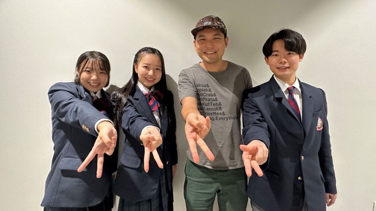 Japanese YouTuber Ghib Ojisan and Japanese high school students giving the peace sign in the AWS Singapore office.
