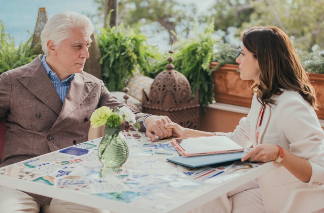 Tommaso Ragno seated across the table from brown haired woman