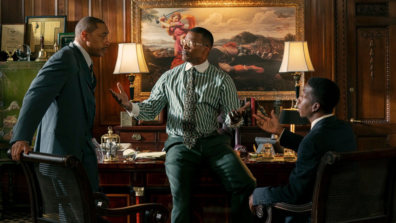 Dorian Missick, Jamie Foxx, and Mamoudou Athie having a lively discussion in an office from the movie, The Burial.