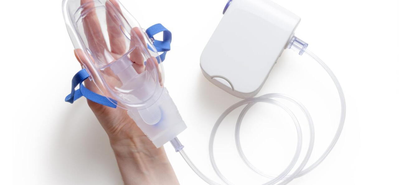 A hand holding an oxygen mask