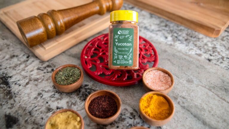 closeup of a variety of ground spices surrounding a bottle of usimplyseason yucatan spice blend