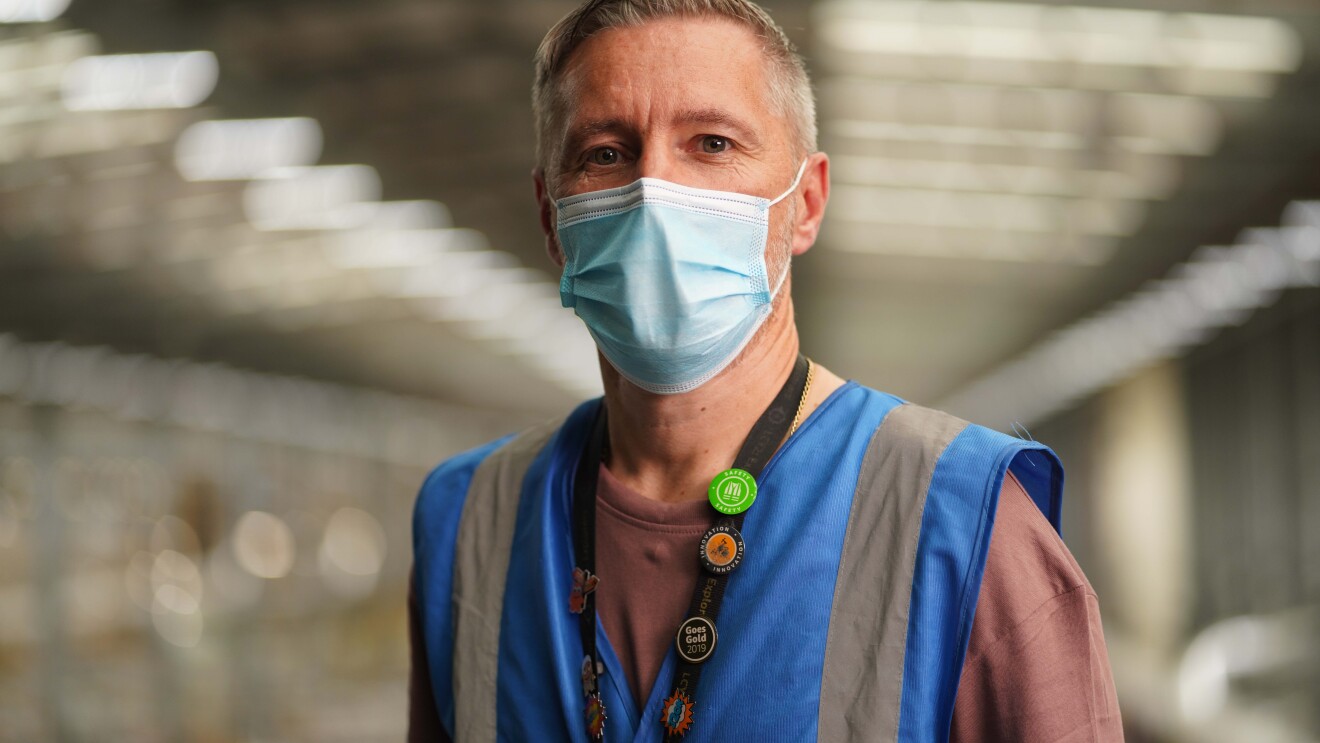 Man wearing a mask inside Amazon fulfilment centre