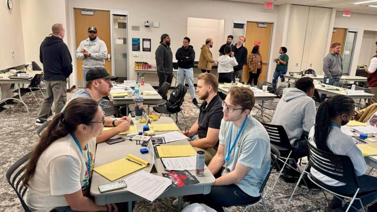 Workshop or training session with participants engaged in various activities and conversations.