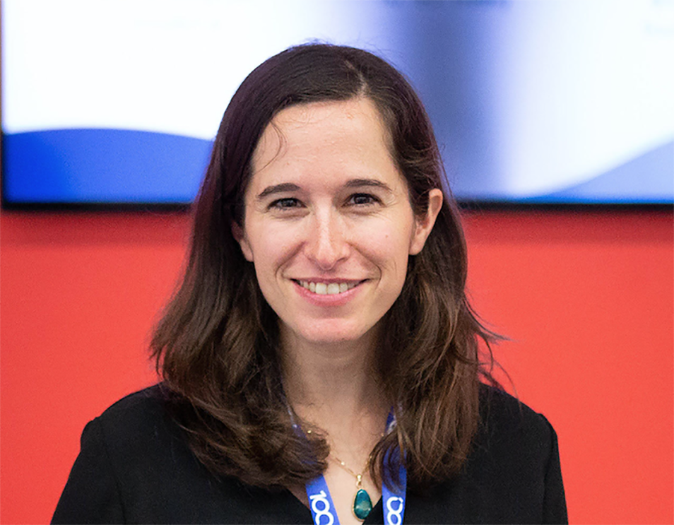 Woman smiles at the camera, in a headshot