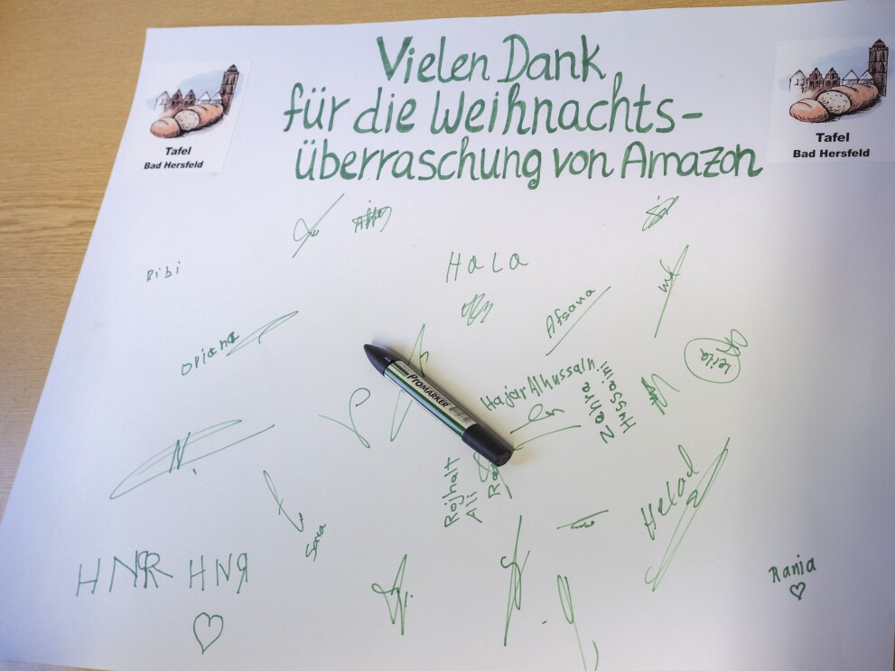 Ein Dankesschreiben der Bad Hersfelder Tafel an Amazon: In grüner Schrift steht fett auf einem weißen Blatt Papier: "Vielen Dank für die Weihnachtsüberraschung von Amazon". Darunter rund ein Dutzend Unterschriften.