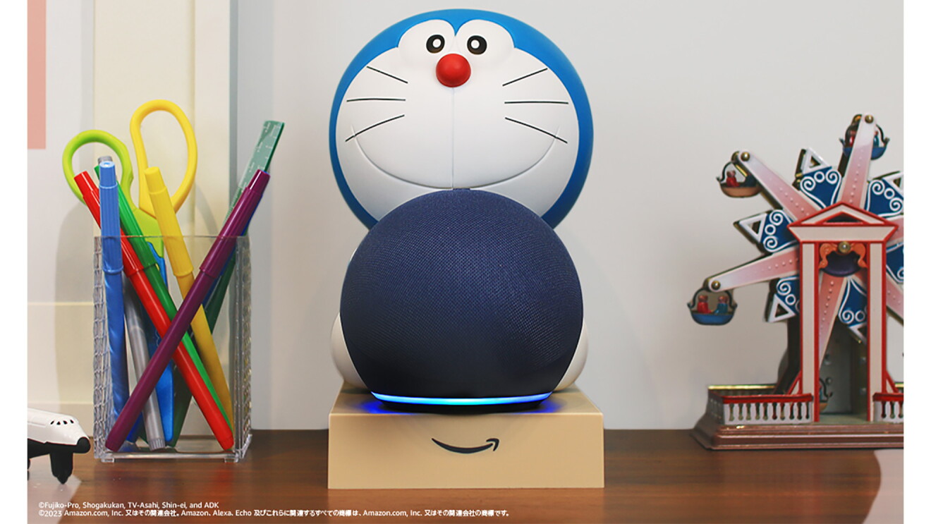 机の上に載っているドラえもんが球体のAmazon Echoをかかえている形状のスタンド