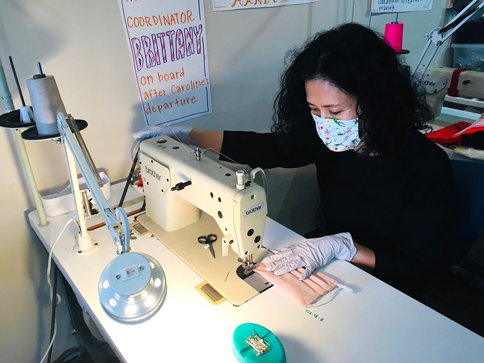 A woman works at a sewing machine.