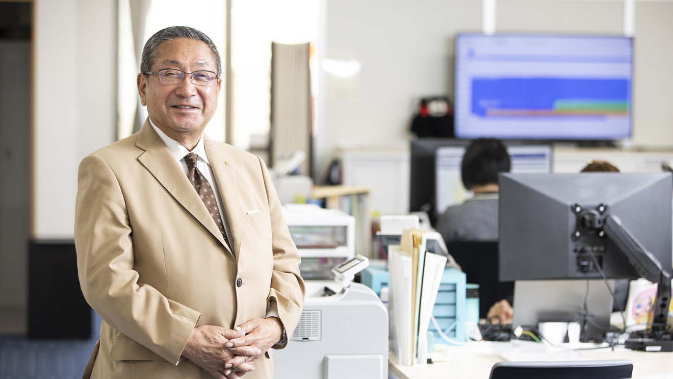 並んだデスクを背景に、笑顔の笠さん