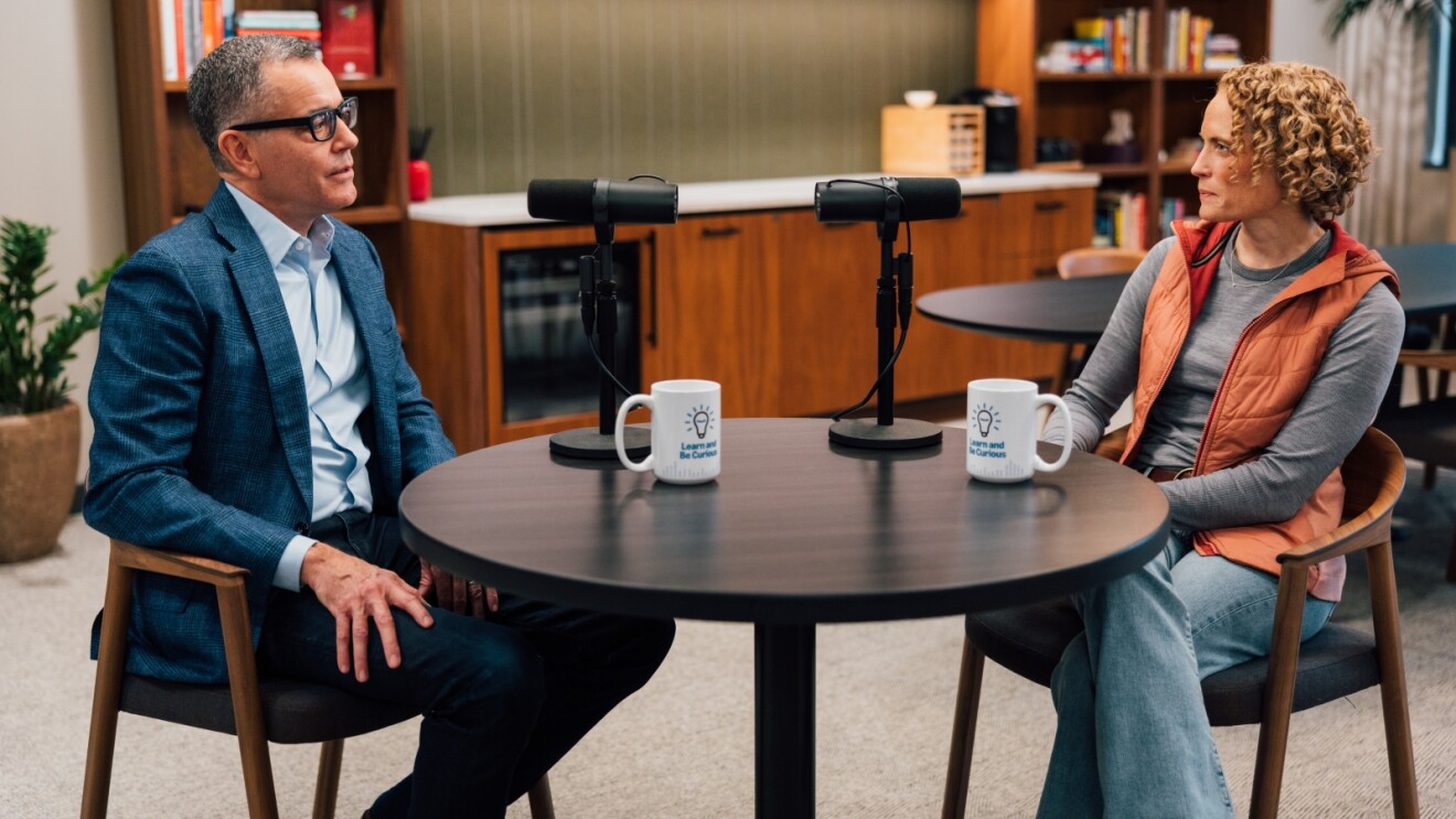 Doug Herrington, Amazon Stores CEO, and Hannah McClellan, an Amazon Pharmacy VP, seated at table, recording podcast