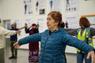 Woman doing arm exercises in quilted jacket