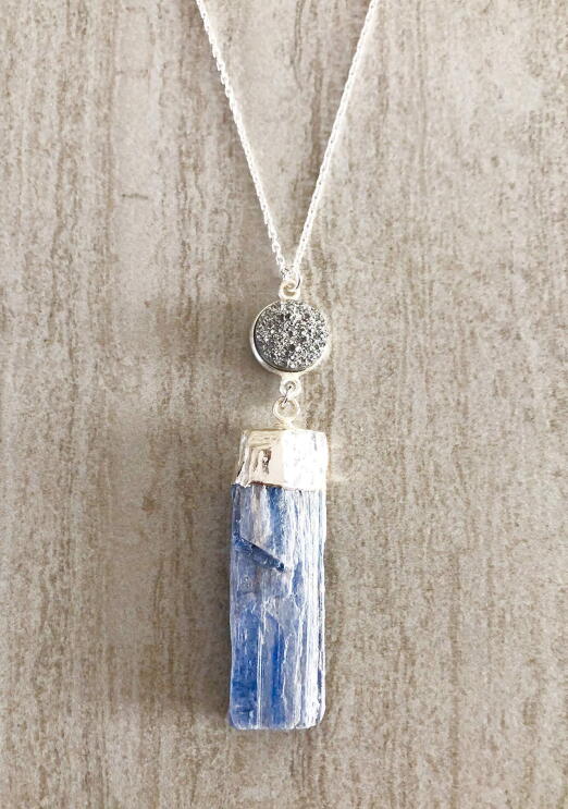 A flat shot of handmade jewelry with raw and semi-precious stones made by T. Victoria.