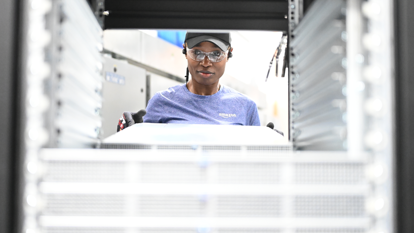 A photo of an employee holding server racks within a data center.