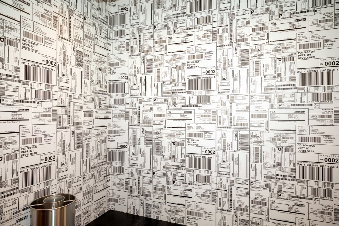 A section of an Amazon tech hub on Boston, a corner of a room papered with shipping labels.