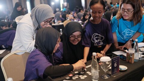 Female students connecting as they work on technology together