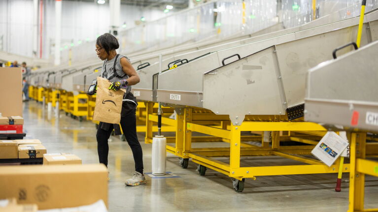 Amazon employee in a fulfillment center sorting packages