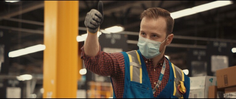 Amazon employee with thumb up and wearing mask