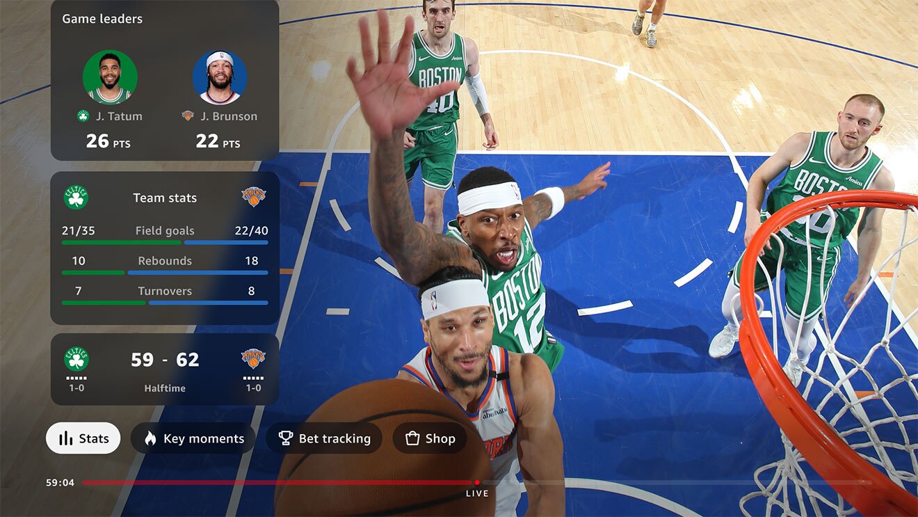 バスケットボールの試合を、ゴール付近の高い視点からとらえたところ。ボールを持つ白ユニフォームの選手の背後で、緑ユニフォームの選手が右腕を高くあげている。左側に選手やチームのデータ表示。