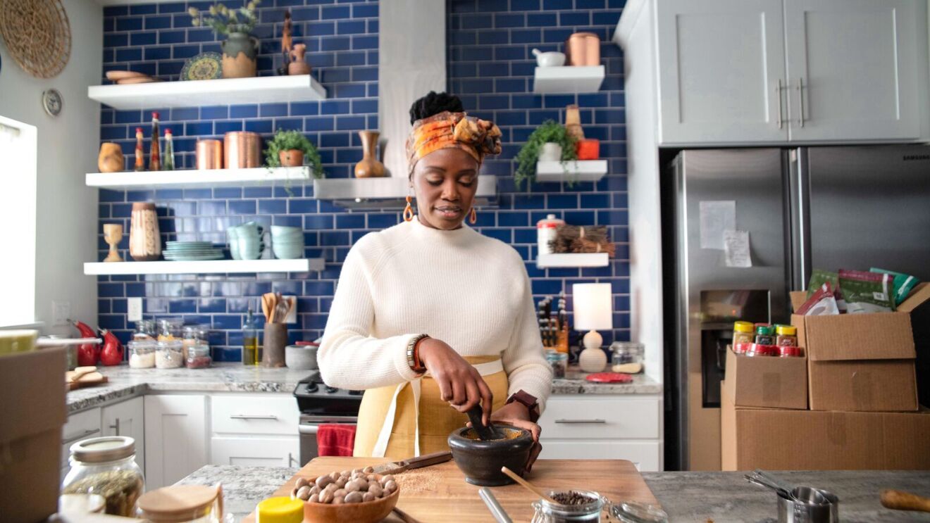 sylvia kapsandoy founder of small business usimplyseason looks down while grinding spices with a mortar and pestle