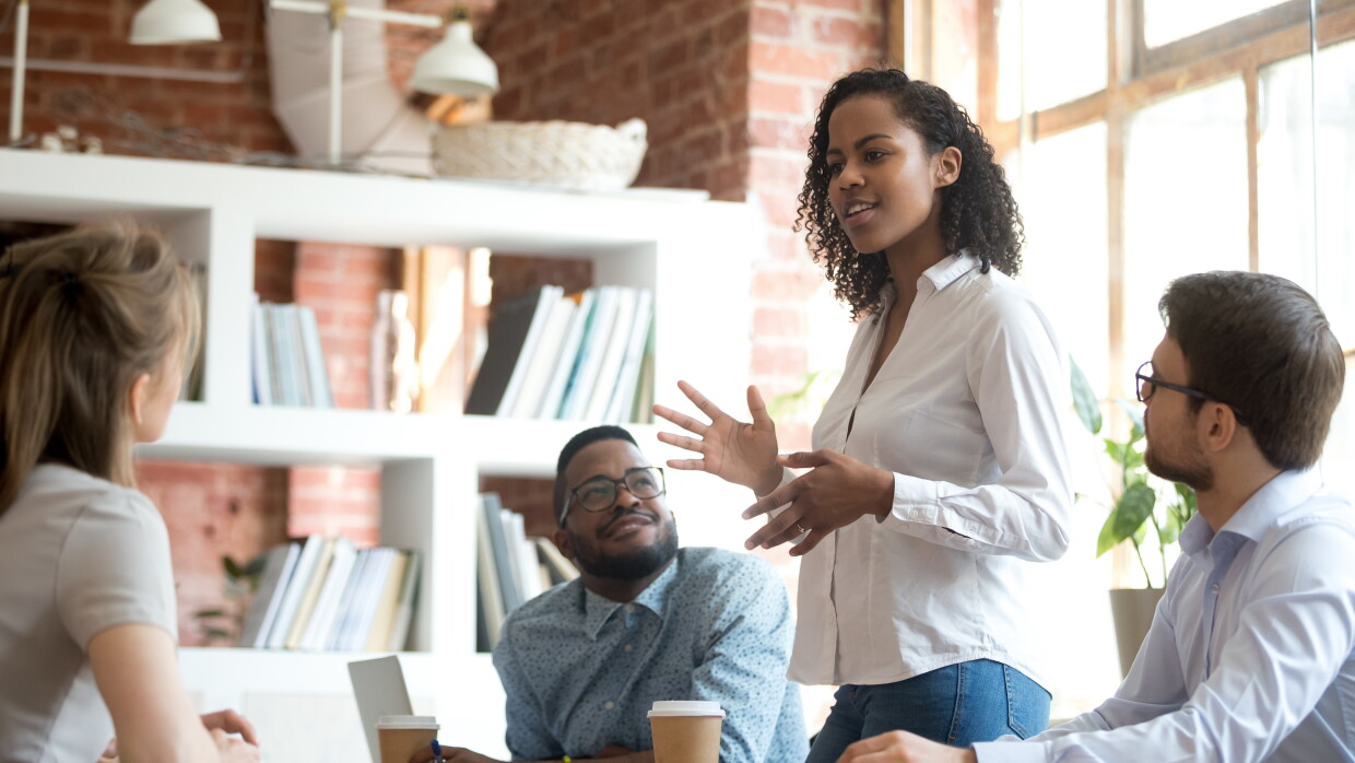 Ambitious african black female employee speaking at diverse meeting